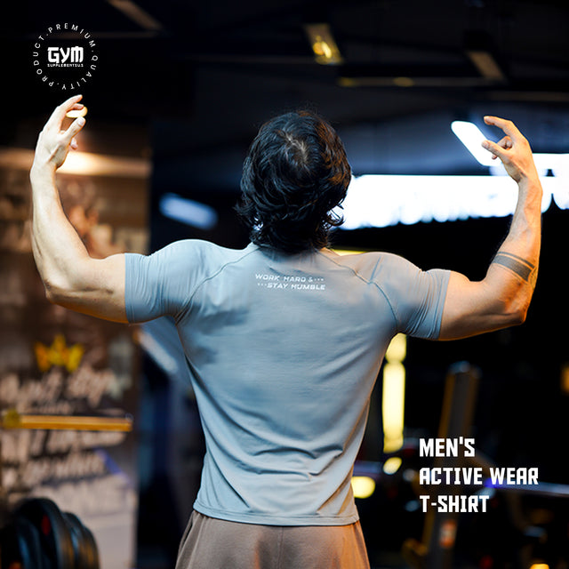 Backside of a grey gym T-shirt featuring the motivational quote “WORK HARD & STAY HUMBLE” printed below the neckline.