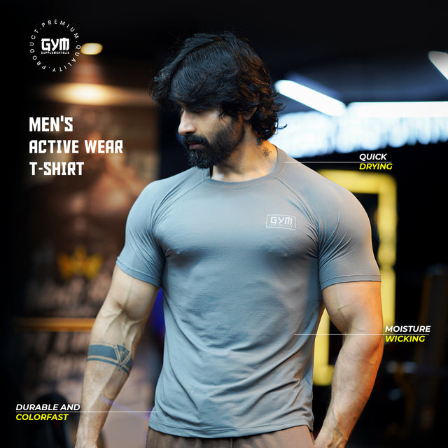 A muscular man wearing a grey Gym Supplements U.S. activewear T-shirt designed for workouts. The shirt is quick-drying, moisture-wicking, and colorfast, ideal for intense fitness training.