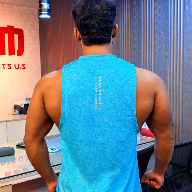 Back view of a men's sky blue muscle tank with "Work Hard & Stay Humble" vertical text design.