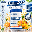 Applied Nutrition BEEF-XP Clear Protein Isolate in Orange & Mango flavor. The 900g tub highlights 30 servings, 27g of protein, 0g of sugar, and 111 calories per serving, along with dairy-free and lactose-free tags. The container is displayed with fresh orange slices, diced mango, ice cubes, and a beverage splash