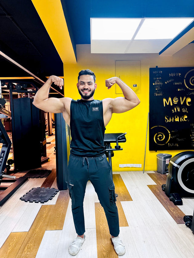 Gym Supplements U.S. brand ambassador wearing a black branded sleeveless fitness shirt in a gym setting