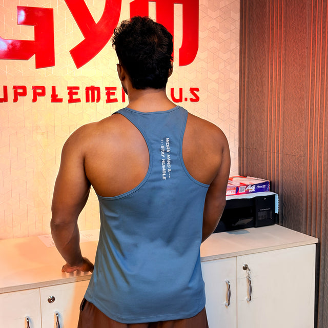 Back view of a grey gym tank top featuring "Work Hard & Stay Humble" text with the Gym Supplements U.S. logo in the background.