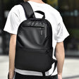 Person wearing the Louis Royaln minimalist black laptop backpack for daily commute, lifestyle back view