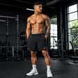 Men wearing black performance training shorts in a modern gym, front view.