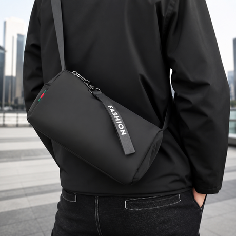 Queshark black waterproof nylon mini crossbody gym bag for men and women featuring a zipper tag with 'FASHION' lettering and adjustable shoulder strap.